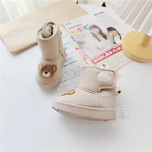 Close-up of cozy beige kids snow boots with plush lining and cute bear detail