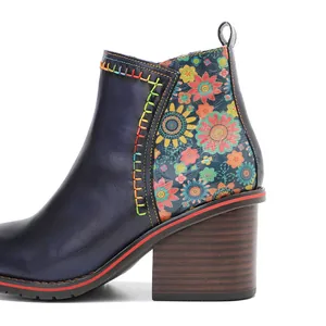 Close-up detail of vintage leather ankle boot with floral patchwork and chunky heel