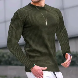 Dettaglio di una maglia in maglia da uomo verde oliva con una particolare trama a quadretti.