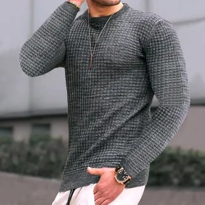 Dettaglio di un maglione da uomo in maglia grigia a scacchi con collo rotondo alla moda