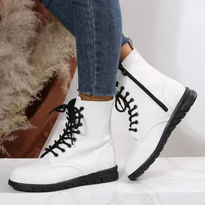Vue détaillée des bottines à plateforme blanches avec lacets noirs et fermeture éclair