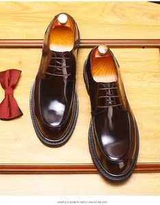 Draufsicht auf glänzende dunkelbraune Leder-Derbyschuhe für Herren auf Holz
