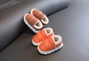 Detailed view of children's waterproof plush-lined snow boots in orange and brown.