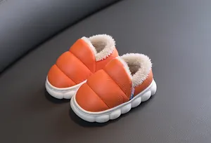 Close-up of bright orange kids' winter snow boots with warm fleece lining