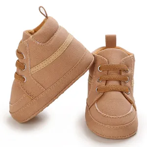 Primer plano de zapatillas altas marrones para bebé con cordones elásticos.