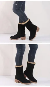 Close-up detail of black mid-calf boots featuring chunky heels and faux-fur collar
