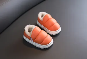 Detail of orange plush lined winter boots for kids with waterproof leather surface
