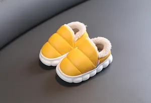 Close-up of yellow waterproof toddler snow boots with plush faux fur lining