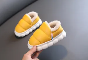 Close-up of yellow waterproof children's winter boots with warm fluffy fleece lining.