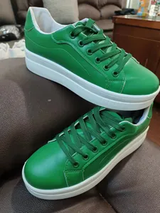 Dettaglio laterale di sneaker platform in ecopelle verde con lacci coordinati.