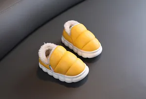 Detailed view of yellow children snow boots with warm white fleece lining