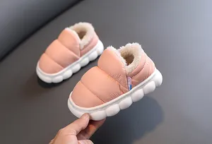 Close-up of pink fur-lined children's snow boots with puffy waterproof fabric