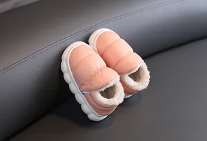 Detailed view of pink plush-lined children's winter snow boots on leather surface
