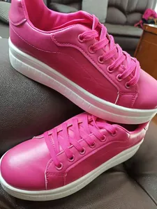 Vista ravvicinata di sneaker fucsia in ecopelle con suole spesse a zeppa bianche