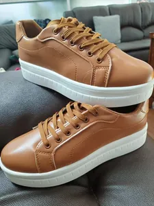 Primo piano di sneakers platform marroni in ecopelle con suola bianca spessa e lacci