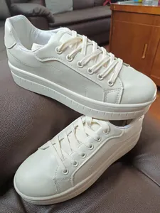 Vista dettagliata di sneaker con plateau crema, suola spessa, lacci e punta arrotondata.