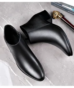 Detailed view of men's black leather Chelsea boots with side zipper and polished finish