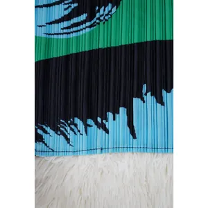 Primer plano de la textura plisada en un vestido de verano con patrones verdes y azules