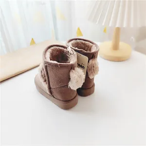 Dettaglio degli stivali da neve marroni per bambini con orecchie di peluche e fodera calda.