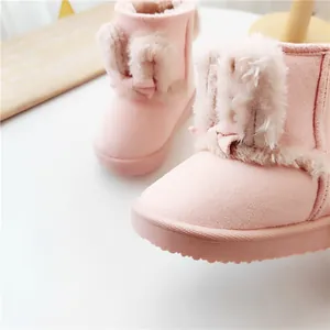 Dettaglio degli stivali da neve rosa per bambini con orecchie di coniglio in peluche e fiocchi