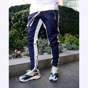 Men's slim-fit track pants with navy and white side stripes and ankle zipper detail