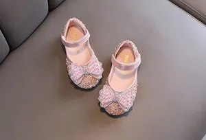 Nahaufnahme von rosa Prinzessinnenschuhen für Mädchen mit glitzernder Schleife und Strass
