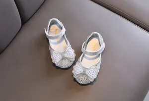 Detailansicht silberner Prinzessinnenschuhe für Mädchen mit glitzernder Schleife und Perlen