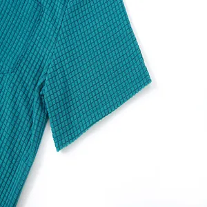 Close-up detail of teal waffle knit fabric texture on a men's short sleeve shirt