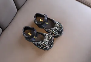 Draufsicht auf funkelnde schwarze Prinzessinnenschuhe für Mädchen mit großer Kristallschleife