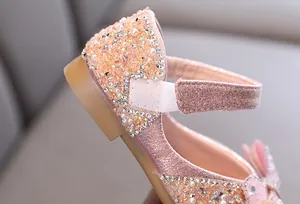 Detailansicht von funkelnden Strasssteinen und Perlen auf einem rosa Glitzerschuh