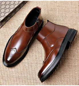 Detail of brown leather brogue Chelsea boots with side zipper and wingtip perforation.
