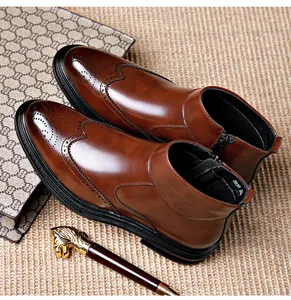 Close-up of brown leather brogue Chelsea boots featuring side zipper and wingtip detailing