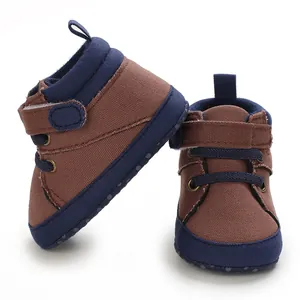 Close-up of brown and blue canvas baby walking shoes with soft high-top design