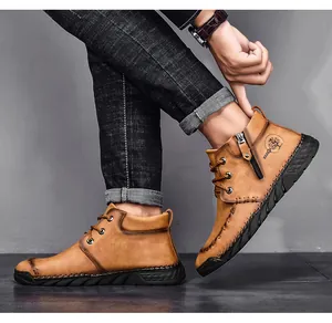 Detail view of men's brown mid-top Martin work boots featuring side zipper and tree logo