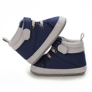 Close-up side view of navy blue and grey baby high-top soft sole walking shoes