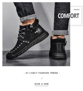 Detail of men's black mid-top work boots with side zipper and white cross-stitching details.
