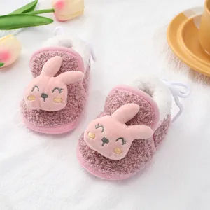 Detailweergave van roze fleece babyschoentjes met een schattig 3D-konijnengezichtje