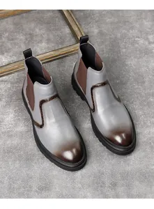 Détail de bottines Chelsea rétro en cuir gris avec un dégradé de couleur marron.