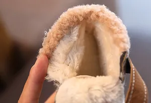 Dettaglio della fodera in pile bianco spessa e calda degli stivali invernali per bambini.