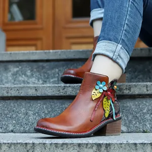 Detalle de botines vintage de cuero marrón con flores 3D coloridas y tacón de madera