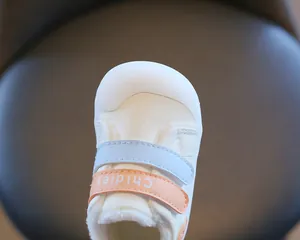 Close-up of fleece-lined baby toddler shoe with colorful velcro straps and toe cap