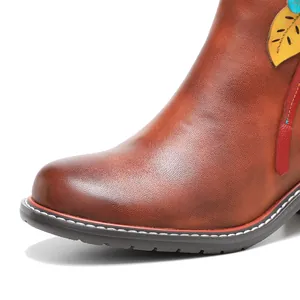 Detalle de cerca de los botines de cuero vintage con patrón floral 3D hecho a mano