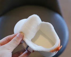 Detailed view showing thick white fleece interior lining of warm winter baby shoes