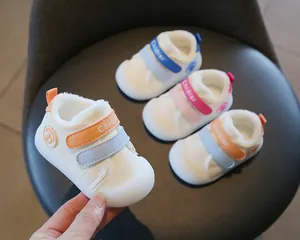 Close-up of warm fleece-lined baby walking shoes with non-slip soft soles in multiple colors.