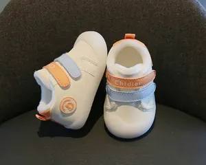Close-up detail of warm white baby walking shoes featuring soft fleece lining and velcro straps