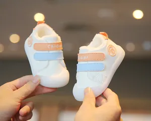 Close-up of white baby winter walking shoes with warm fleece lining and colorful velcro straps