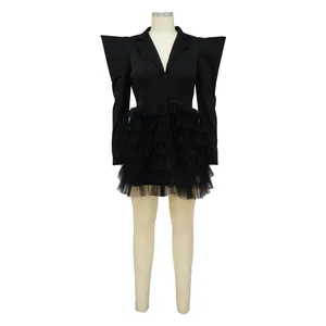Detail of black blazer dress with exaggerated shoulders and tiered ruffled tulle skirt