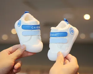 Close-up of white baby winter shoes with blue straps and soft plush lining