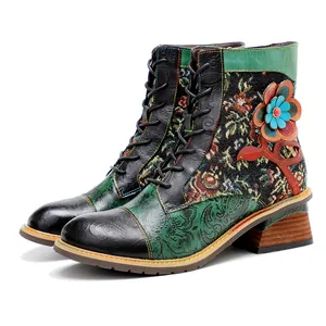 Dettaglio stivaletti in pelle patchwork floreale retrò con tacco largo e fiore 3D.