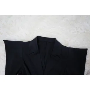Close-up detail showing the collar and structured shoulders of an elegant black dress